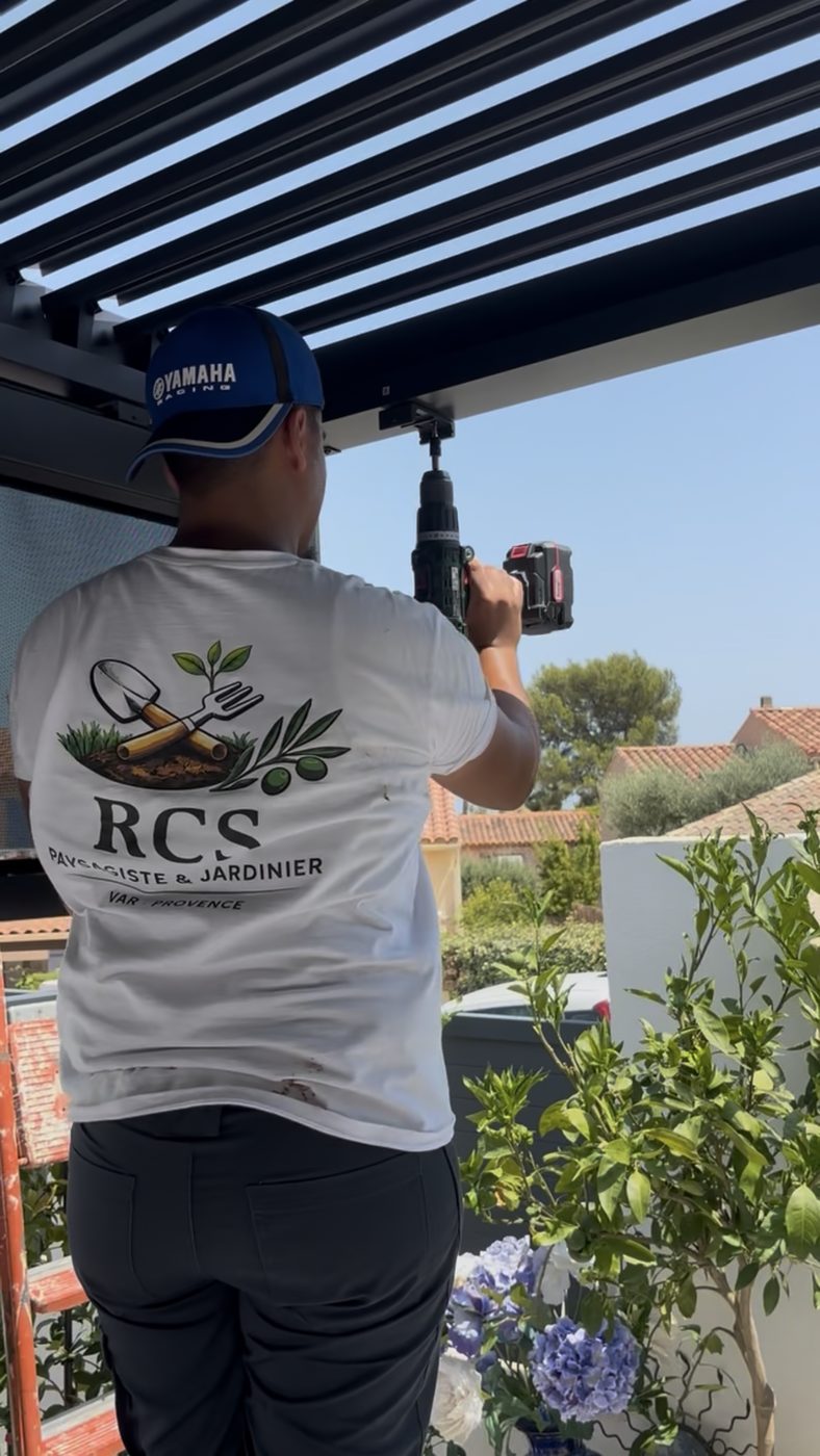Ouvrier RCS fixant les lames d'une pergola bioclimatique