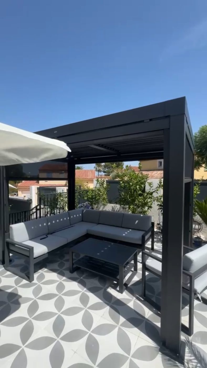 Pergola bioclimatique terminée avec salon de jardin
