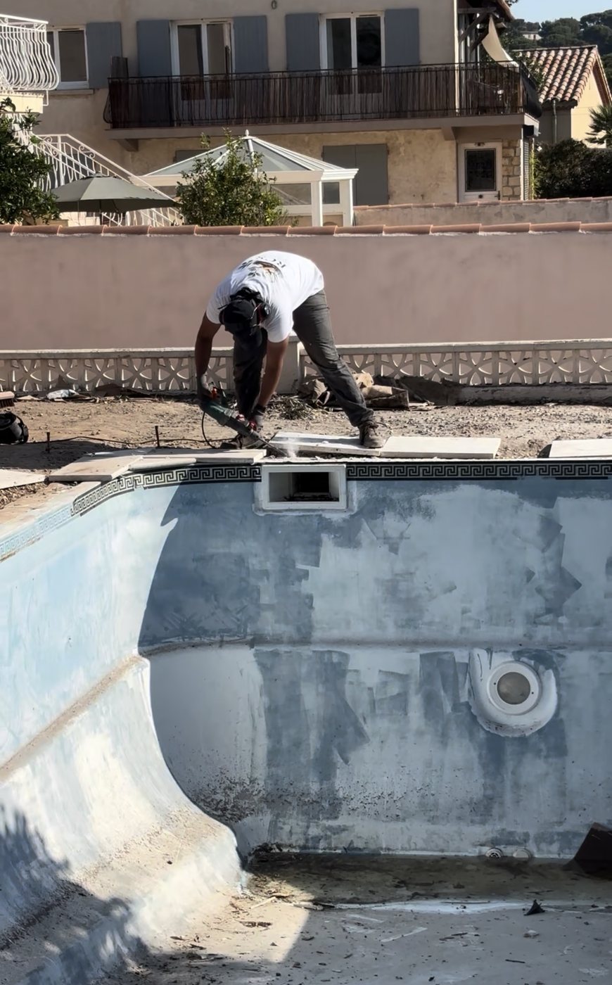 Ouvrier RCS déposant les anciennes margelles d'une piscine vide