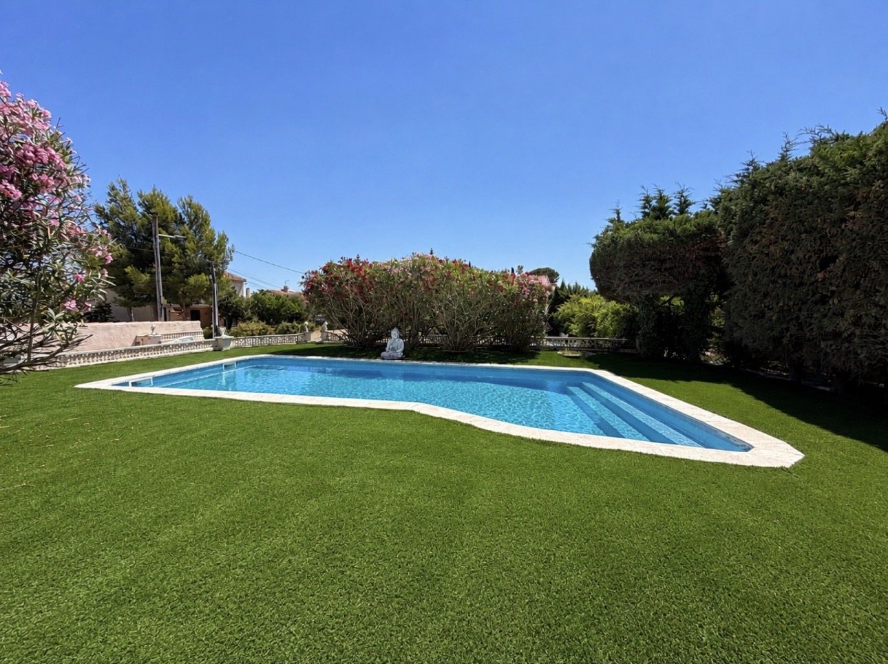 Piscine entourée de gazon synthétique posé par RCS
